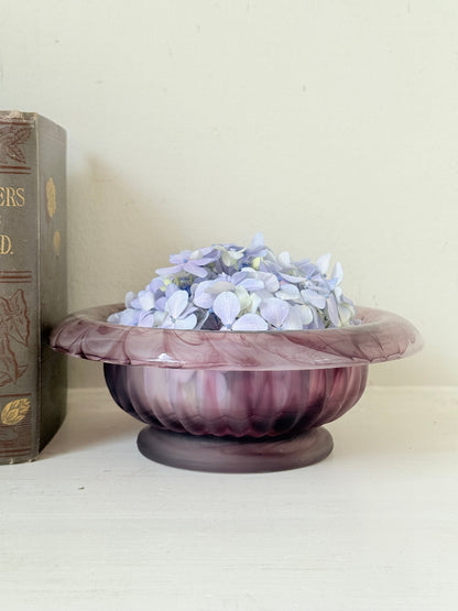 Davidson Cloud Glass bowl in amethyst with swirl pattern and footed base, styled with books and hydrangeas