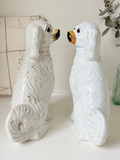 Near pair of antique white Staffordshire spaniel mantel dogs with glass eyes and worn gilt collars