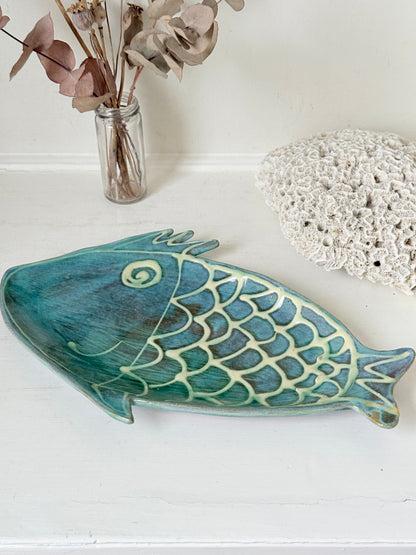 Barbados studio pottery fish platter in turquoise and sea green glaze photographed on a white surface