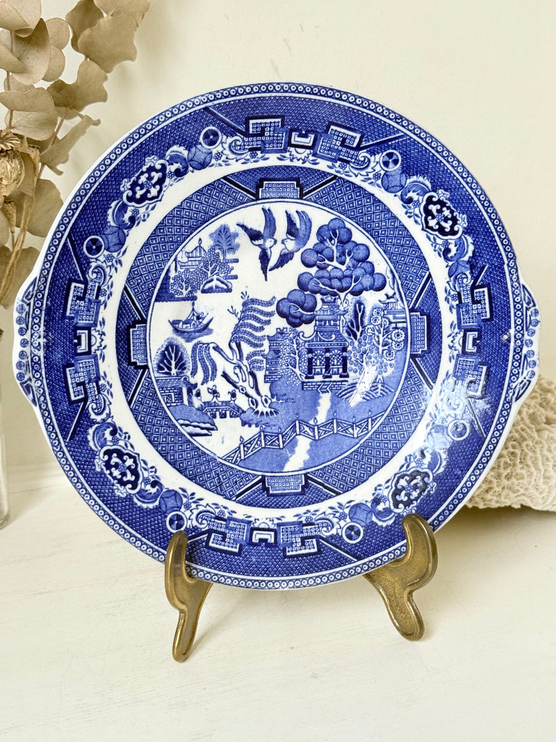 Blue Willow serving plate with cobalt blue transfer pattern shown on a white surface.