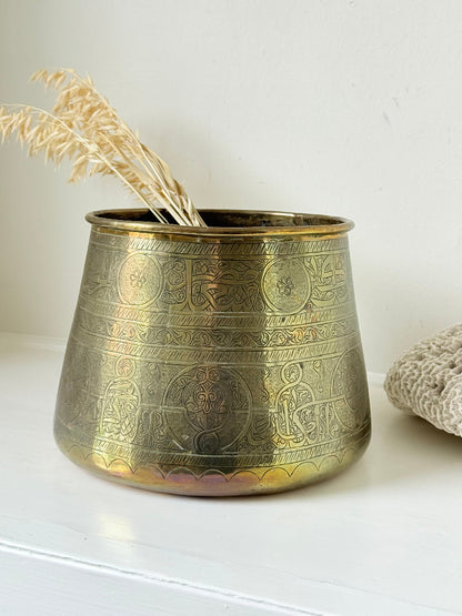 Large vintage brass pot with engraved decoration and aged patina, photographed on a white surface