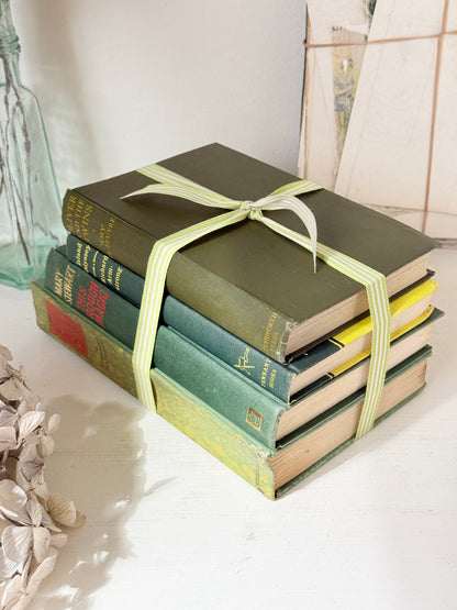 Bundle of vintage sage and olive green cloth books with red spine detail tied with a pale ribbon for styling