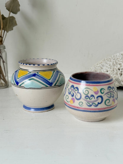 Pair of vintage studio pottery pots in blue green and pink glaze photographed on a white surface