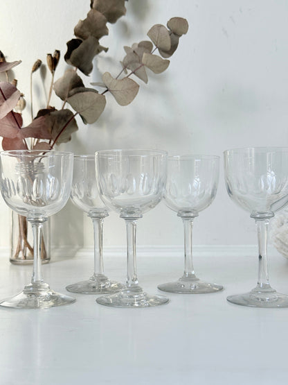 Set of 5 vintage clear glass liqueur glasses with small stems photographed on a white surface
