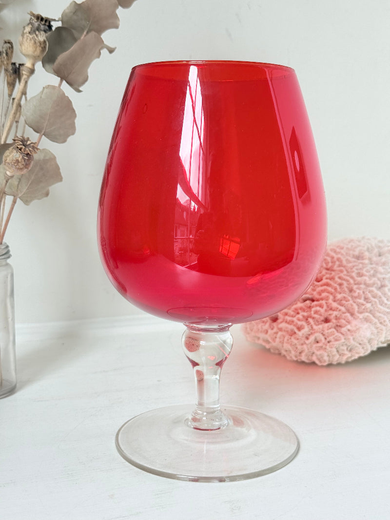 Large retro red glass brandy glass displayed on a white background.
