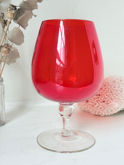 Large retro red glass brandy glass displayed on a white background.