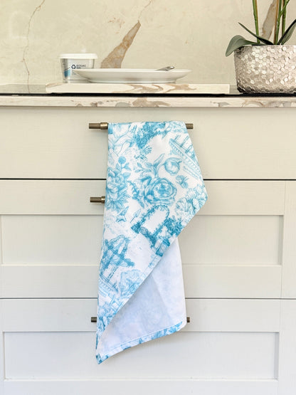 Blue Loft cotton tea towel duo with turquoise gingham check and blue toile pattern photographed in a kitchen setting.