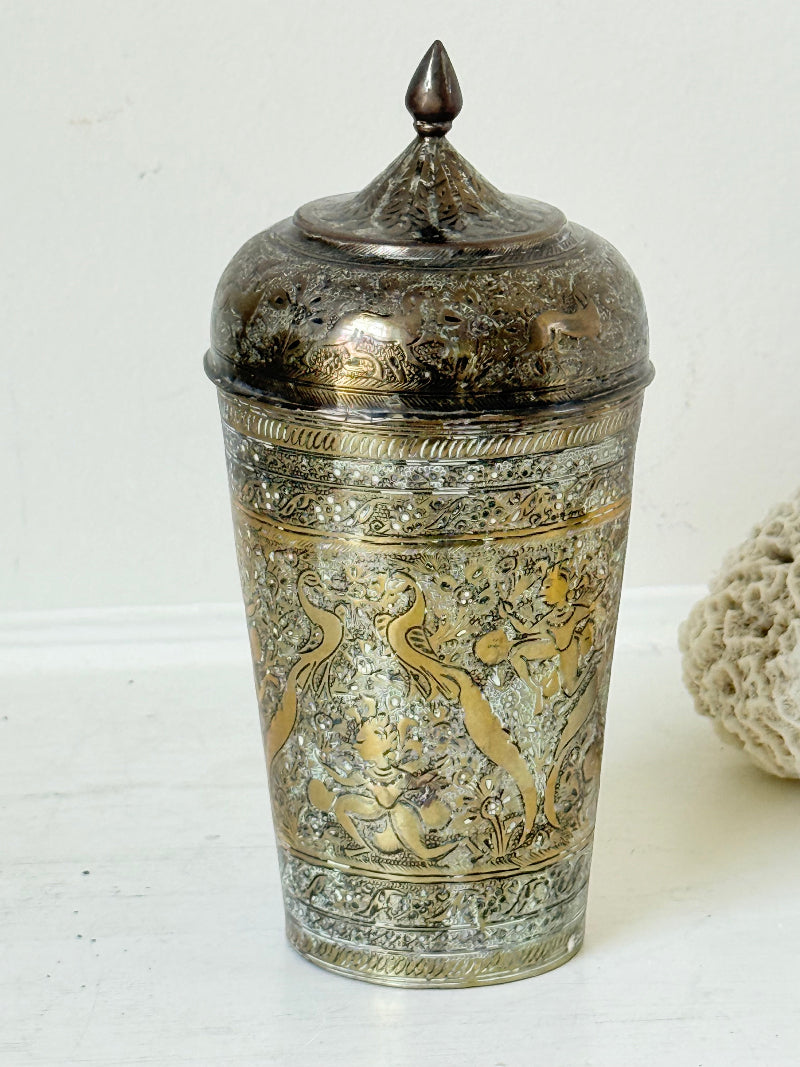 Indian Benares brass jar with lid and engraved animals and floral design, photographed on a white surface