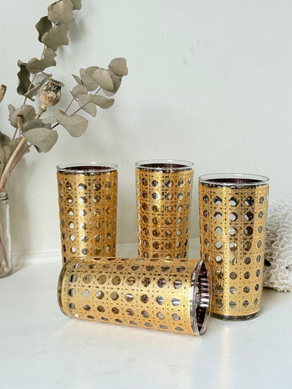 Set of 4 vintage gold rattan effect glasses with pierced lattice sleeves, photographed on a white surface
