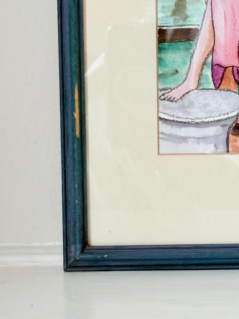 Vintage bright watercolour portrait of a seated woman in pink hat and dress with blue jacket, framed in blue wood with off-white mount, photographed on a white surface.