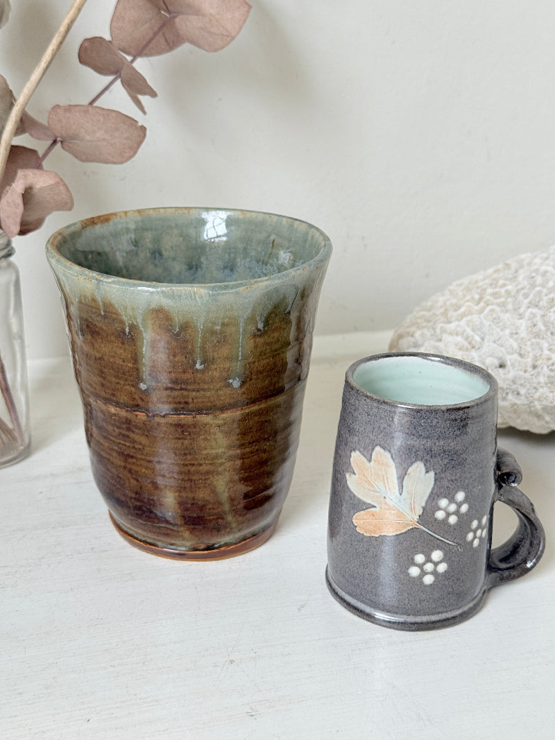 Pair of studio pottery mugs with complementary glazes photographed on a white surface