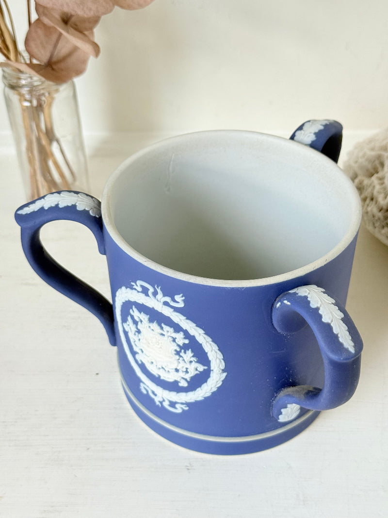 Adam’s blue jasperware loving cup with white classical relief decoration photographed on a white surface.