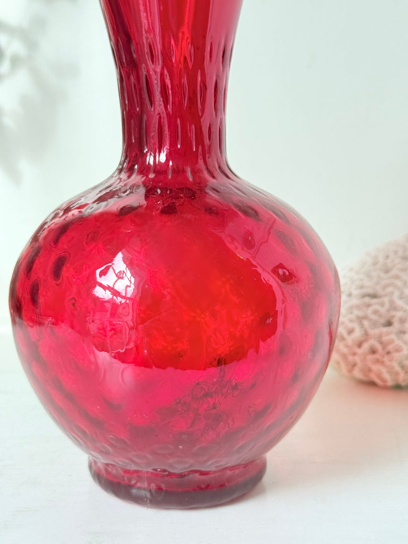 Italian red glass vase with strawberry textured surface, photographed on a white background.