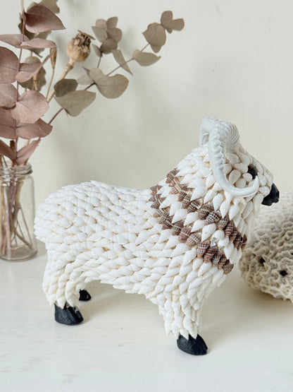Vintage shell ram ornament in cream and brown, photographed on a white surface