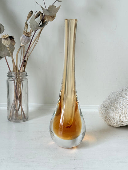Amber and clear 1960s glass vase with narrow neck and rounded base, photographed on a white surface with dried stems.