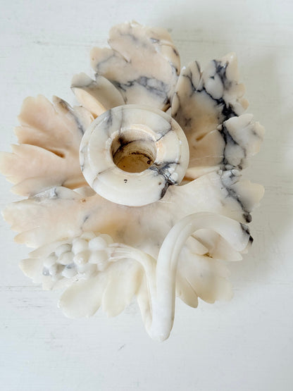 Antique alabaster marble floral candleholder with carved leaves and flowers, photographed on a white surface.
