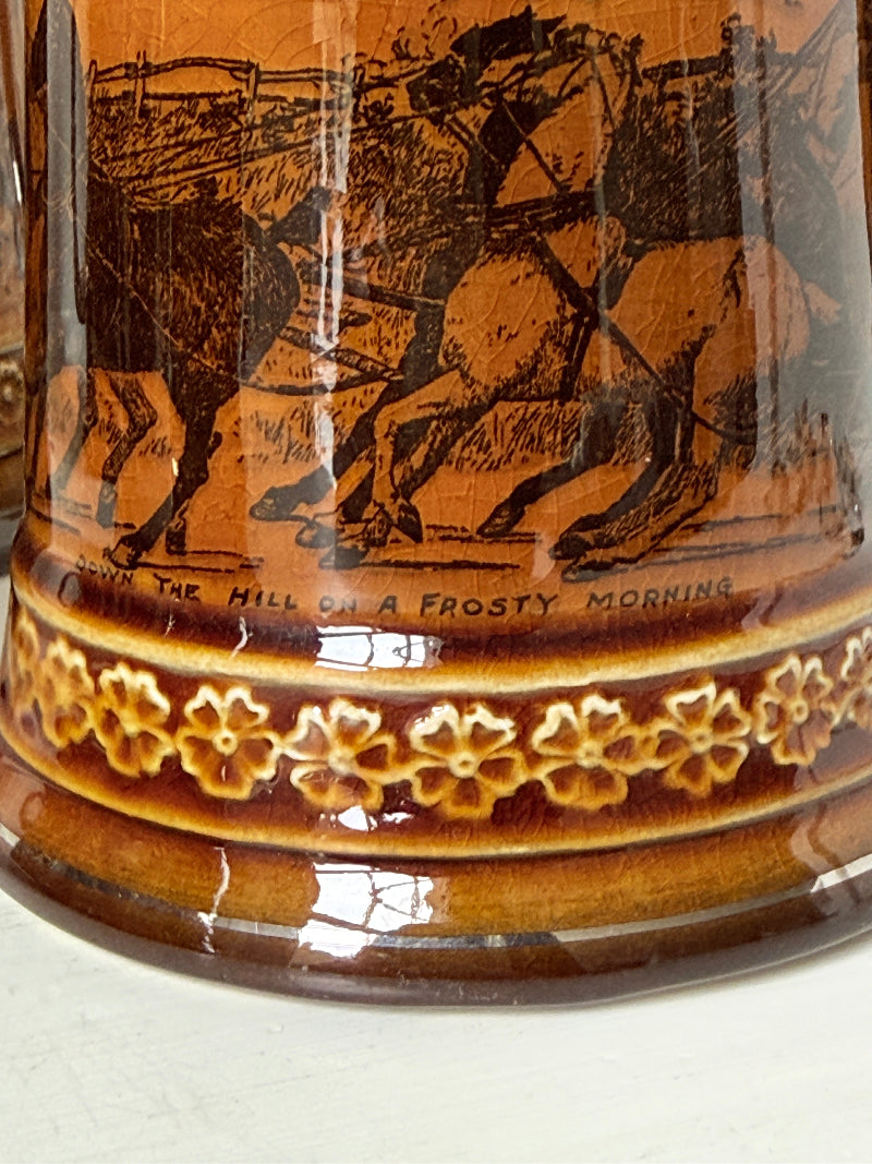 Set of 4 antique Ridgway stoneware beer tankards photographed on a white surface in amber treacle glaze with black Coaching Days and Coaching Ways scenes