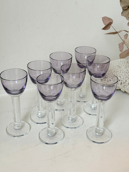 Set of 8 vintage lilac tinted liqueur glasses on a white surface