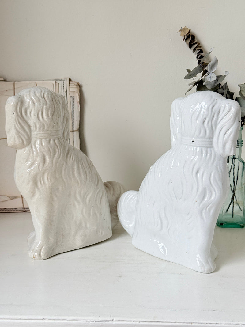 Near pair of antique white Staffordshire spaniel mantel dogs with glass eyes and worn gilt collars