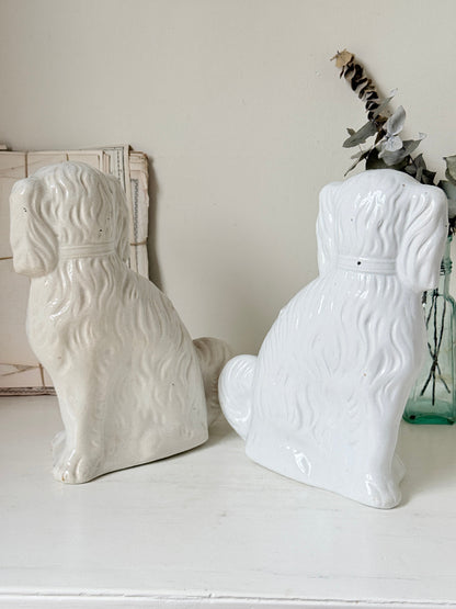 Near pair of antique white Staffordshire spaniel mantel dogs with glass eyes and worn gilt collars