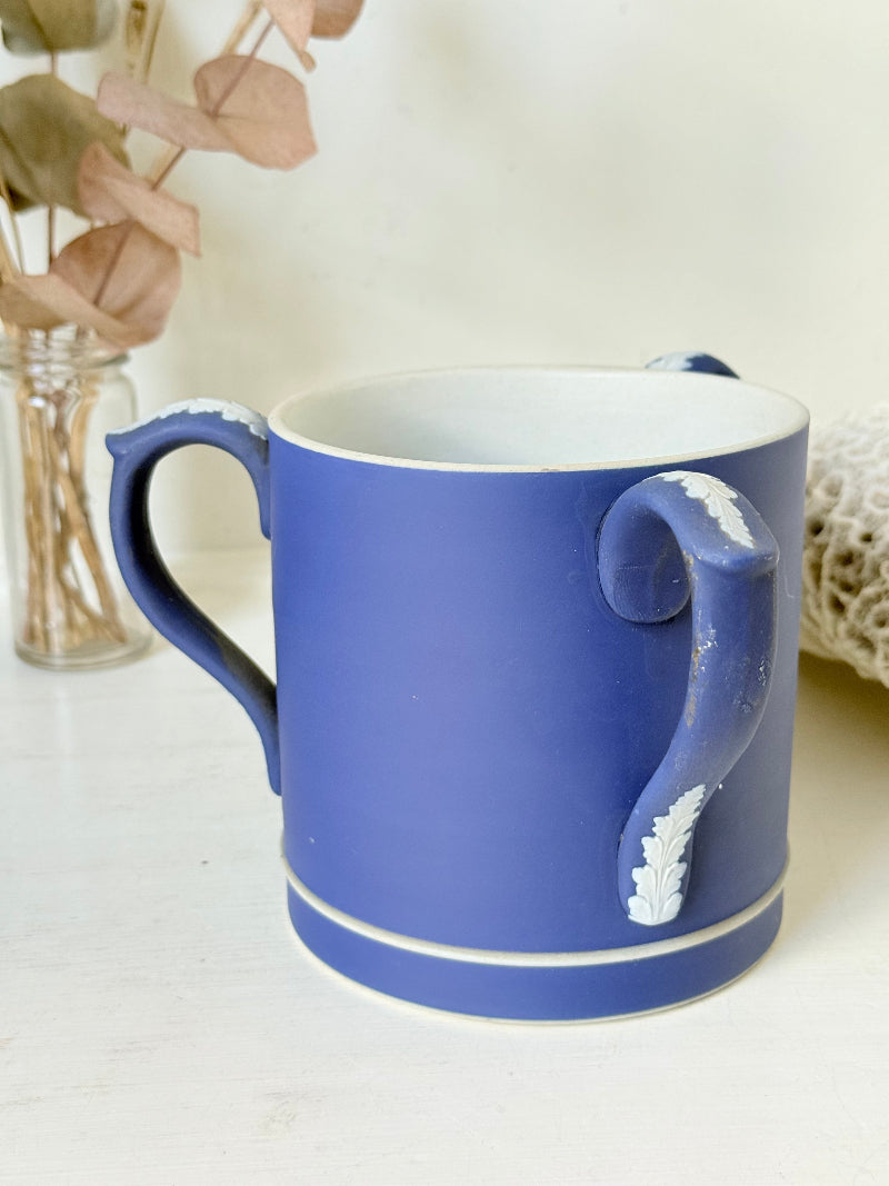 Adam’s blue jasperware loving cup with white classical relief decoration photographed on a white surface.