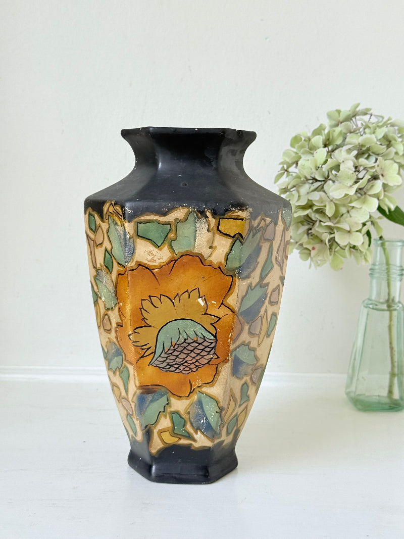 Art Deco Brentleigh Ware vase with hand painted floral design in orange, yellow, and teal on a black ground, photographed on a white surface