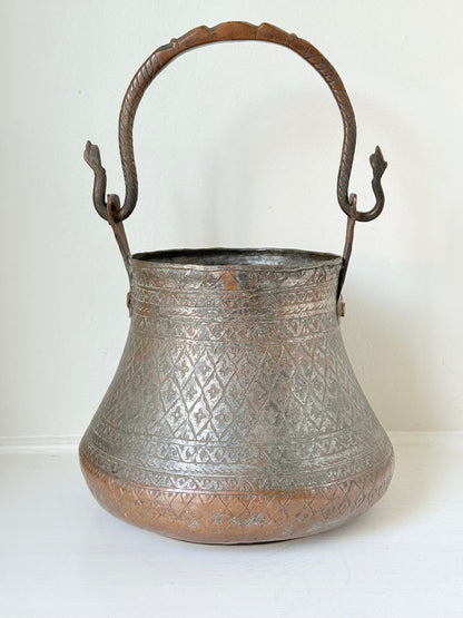 antique Middle Eastern water ewer with engraved diamond and foliate pattern and copper base, displayed on white surface