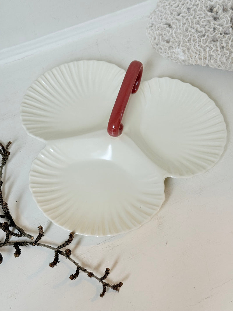 Poole Pottery double scallop hors d’oeuvre dish in white glaze with red handle photographed on a white surface