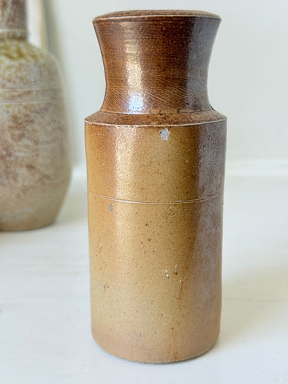 Three antique stoneware bottles, a printed Caley of Norwich and a Portuguese Campos Filhos, photographed on a white surface