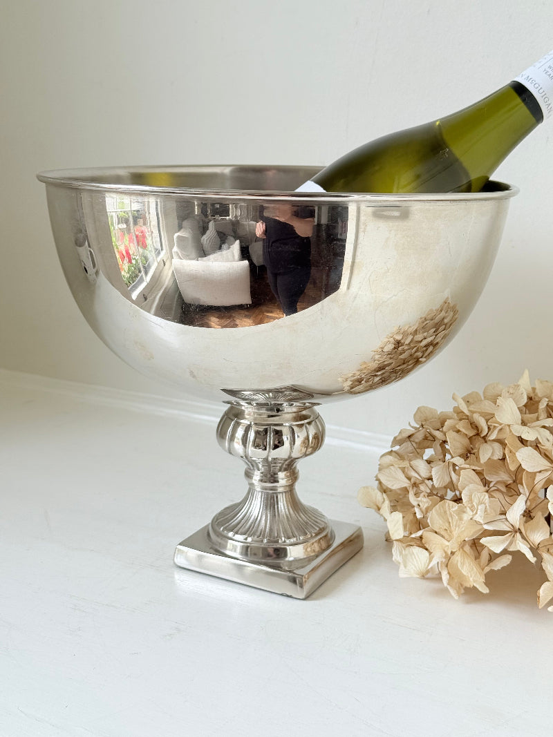 Vintage polished metal champagne bowl with pedestal base, photographed on a white surface