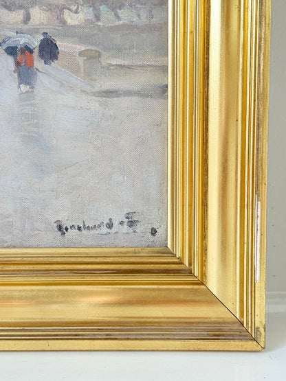 Close-up of a framed painting showing part of a snowy street scene with two figures carrying umbrellas, rendered in muted gray, white, and blue tones, with a prominent gold frame.