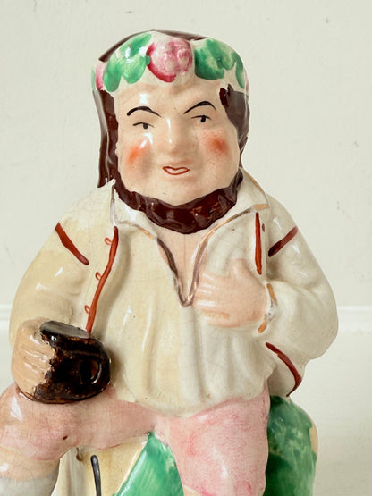 Bacchus antique Staffordshire pottery figure with painted details, photographed on a white surface.