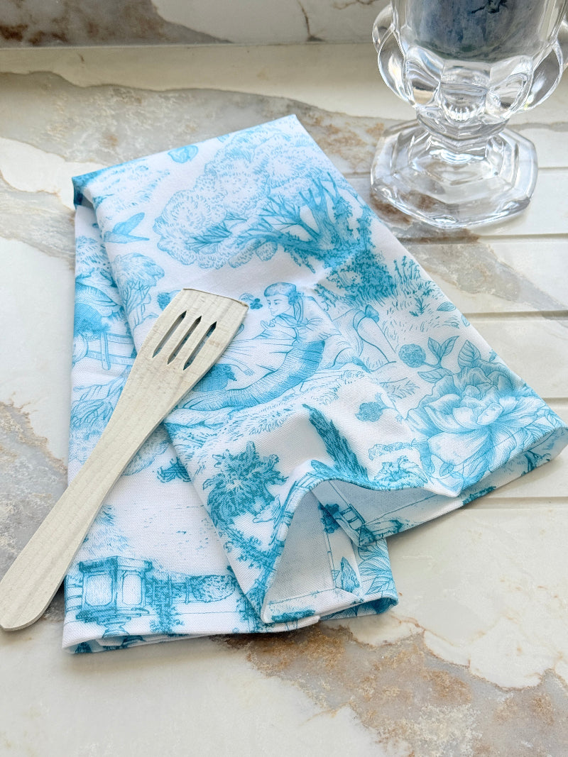 The Blue Loft toile cotton tea towel in turquoise on white with rural scenic print