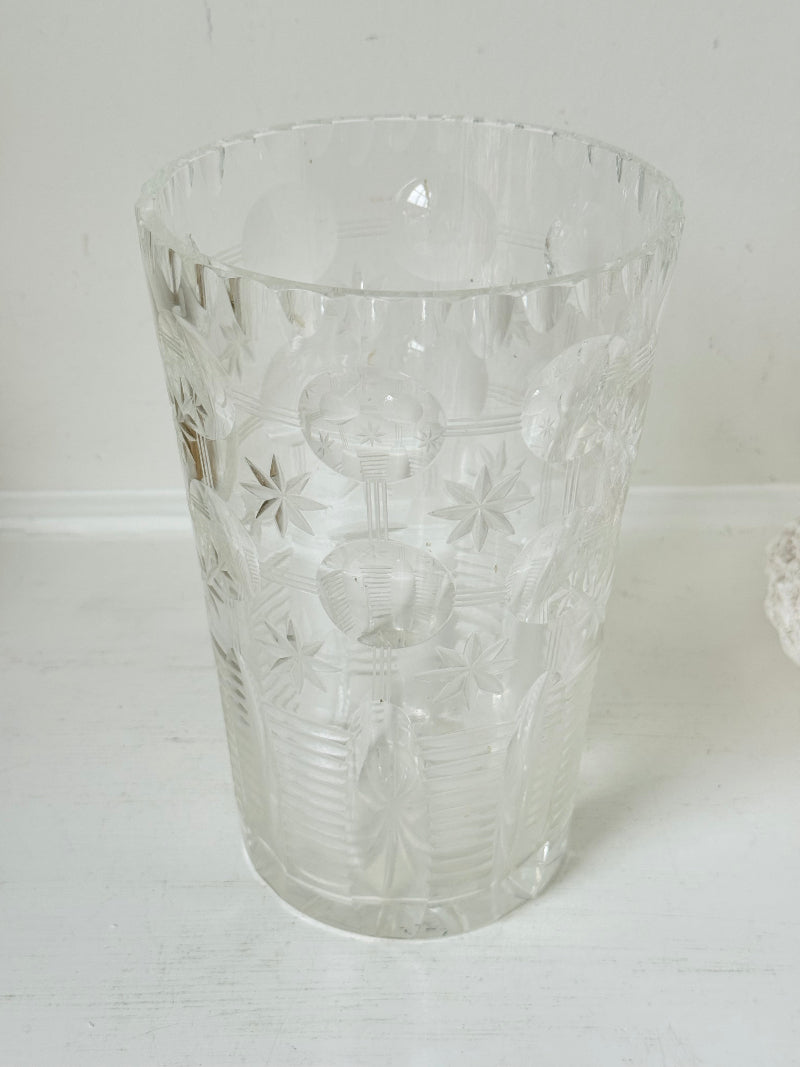 Vintage Stuart crystal cut glass vase with floral and star design, photographed on a white surface.