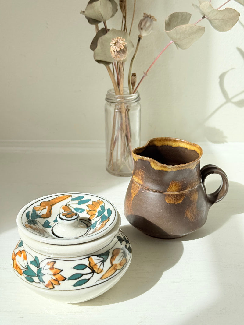 Studio pottery creamer and hand painted sugar bowl set, photographed on a white surface