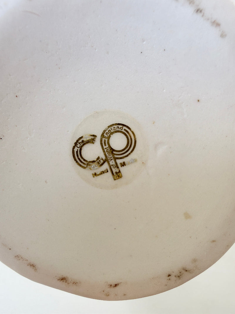 White Chessell Pottery studio vase with rippled rim and raised aqua floral decoration photographed on a white surface