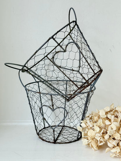 Pair of vintage decorative wire baskets with heart detail and aged patina photographed on a white surface