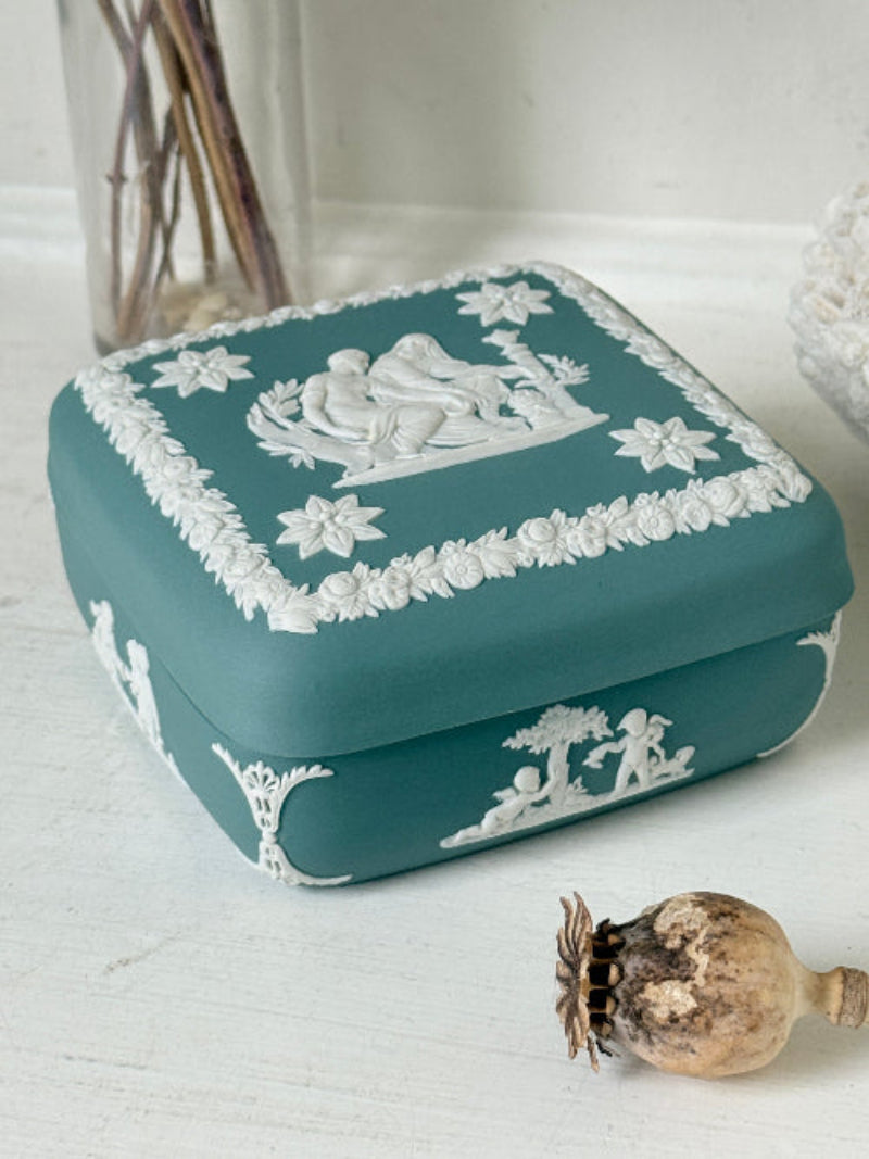Vintage Wedgwood Jasperware teal green square lidded trinket box, decorated with white neoclassical figures and florets, styled with dried stems.