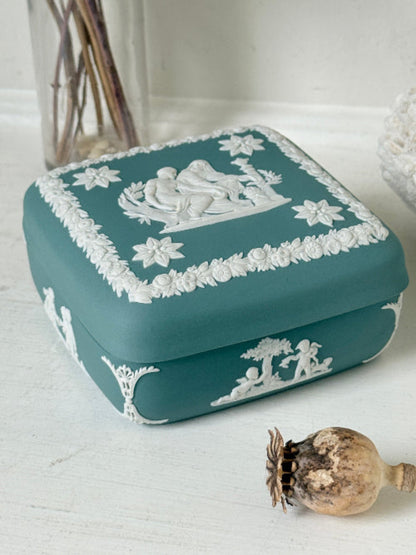Vintage Wedgwood Jasperware teal green square lidded trinket box, decorated with white neoclassical figures and florets, styled with dried stems.