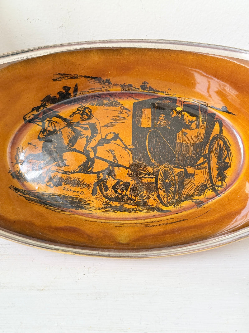 Antique Ridgways stoneware oval dish photographed on a white surface in amber treacle glaze with black Coaching Days and Coaching Ways transfer scene