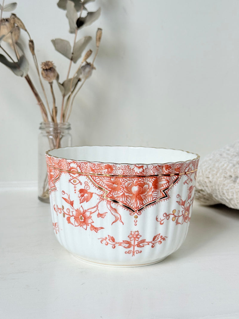vintage porcelain sugar bowl with coral transfer design and gilt rim on white surface