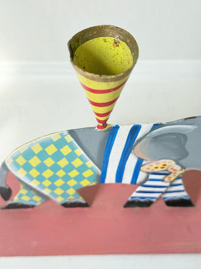 Hand painted metal elephant candlestick in circus-style decoration with colourful patterns, photographed on a white surface