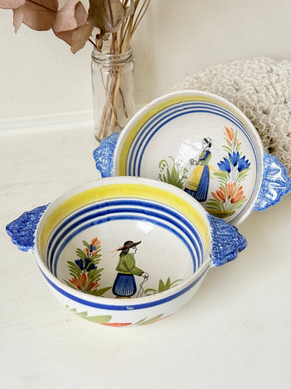 Pair of vintage French Quimper Breton figure bowls with blue handles, photographed on a white surface