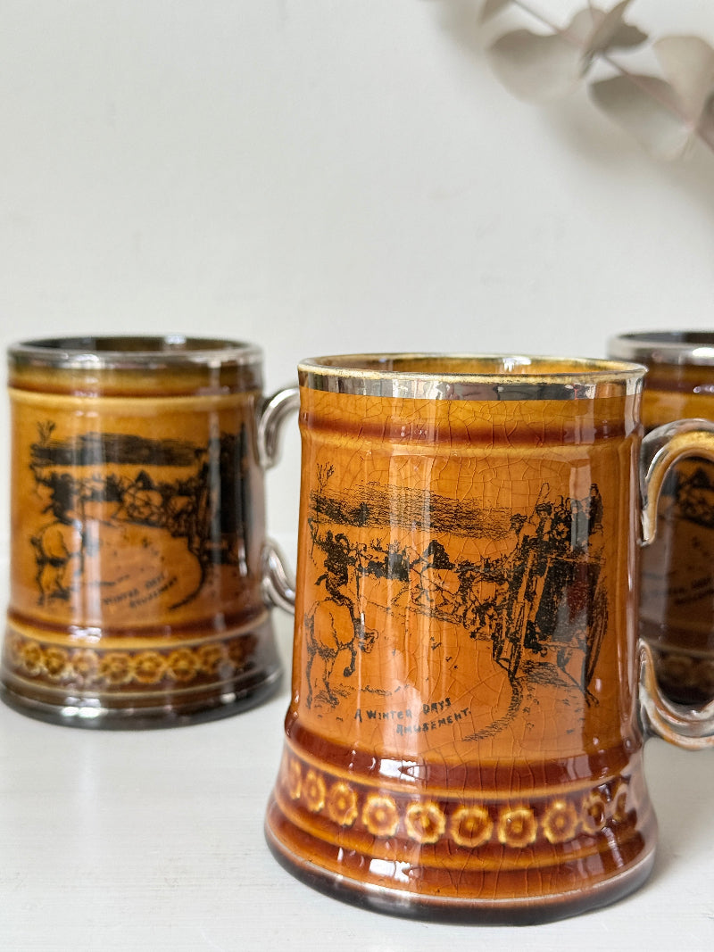 Set of 4 Ridgways stoneware tankard mugs photographed on a white surface in amber brown glaze with black Coaching Days and Coaching Ways transfer scenes