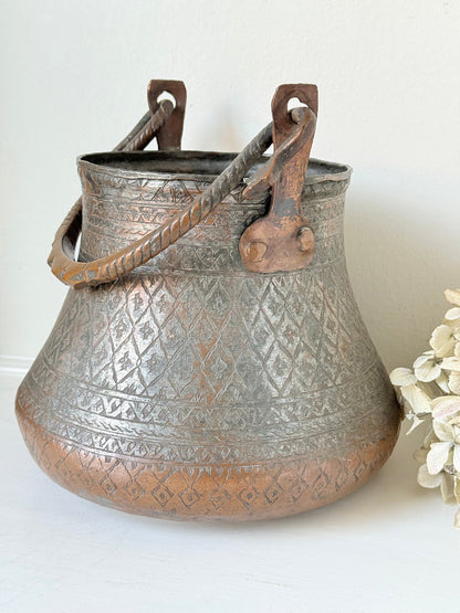 antique Middle Eastern water ewer with engraved diamond and foliate pattern and copper base, displayed on white surface