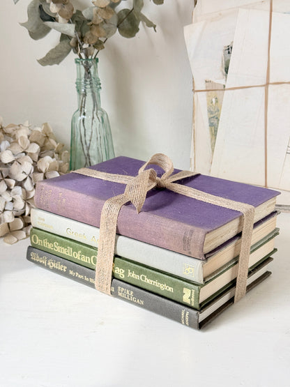 Bundle of vintage books with a heather purple cloth cover over green and cream spines tied with natural twine