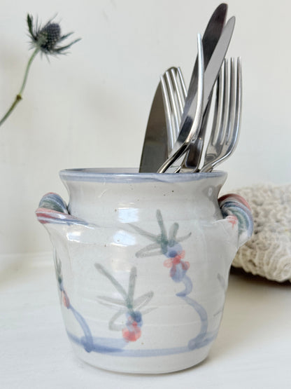 Vintage studio pottery utensil pot with hand painted floral decoration and applied handle detail, photographed on a white surface