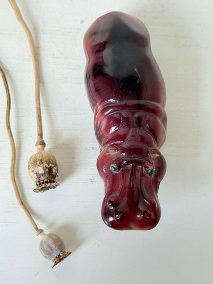 Red polished stone hippopotamus ornament displayed on a white background.