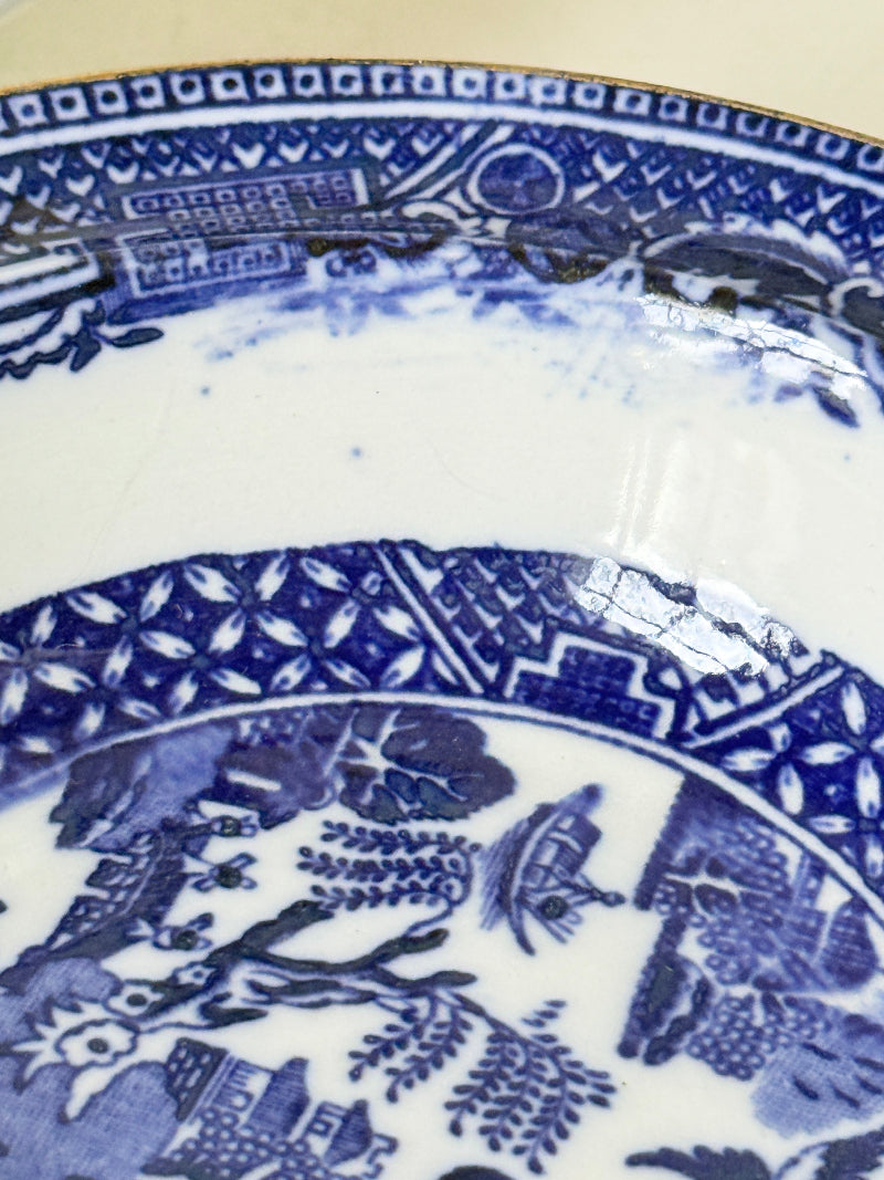 Pair of vintage blue and white Blue Willow snack bowls with patterned border photographed on a white surface