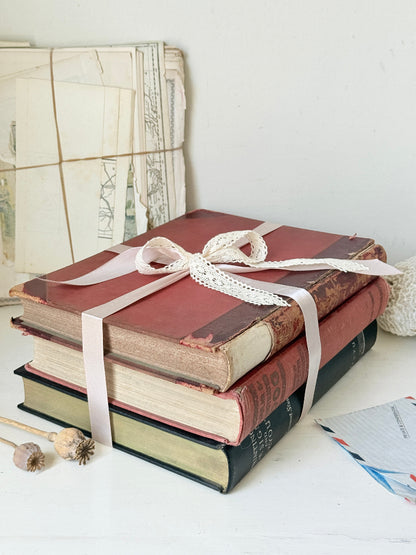 Large vintage decorative book bundle with burgundy cream and green hardback covers tied with ribbon for interior styling